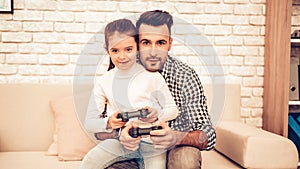 Joystick in Hand. Father and Daughter. Spend Time Together. Father`s day. Man Playing with Girl. Video Game. White Interior.