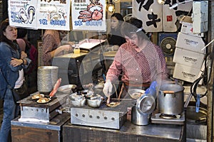 Cook preparing fresh clams at the Tsukiji fish market in Tokyo Japan