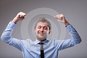 Jubilant happy man cheering and punching the air