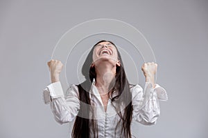 Jubilant woman laughing and clenching her fists