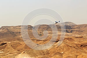 Judaean Desert mountain panorama with wadis and airplane seen from Masada fortress, Israel