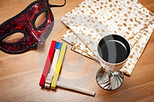 Judaism and religious jewish holiday with matzos unleavened flatbread, cup of wine, wooden noisemaker or gragger a traditional