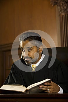 Judge With Book Looking Away In Court Room