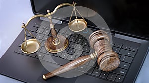Judge gavel and balanced scale standing on laptop computer keyboard. 3D illustration