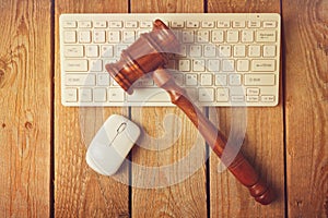 Judge gavel and computer keyboard on wooden vintage background
