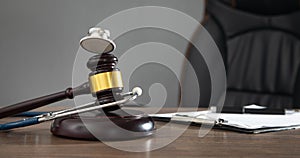 Judge gavel, documents and stethoscope on the wooden table