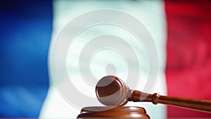 A judge gavel with a flag of France on background. Close up of wooden hammer and legal lawyer books or codex. Sentence