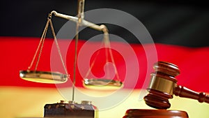 A judge gavel with a flag of Germany on background. Close up of wooden hammer and legal lawyer books or codex. Sentence