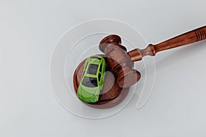 Judge gavel and green toy car on white background. Symbol of law, justice and car auction.