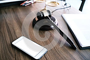 Judge gavel hammer with smartphone on Lawyer desk.