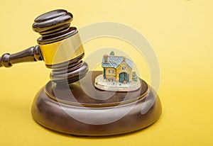 Judge gavel and home icon on yellow background, real estate and law theme