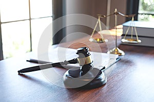 Judge gavel with Justice at law firm in background with legal case document contract, law and justice, attorney, lawsuit