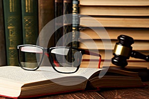 Judge gavel and legal book collection with eyeglasses on wooden