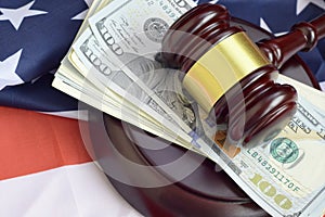 Judge gavel and money on United States of America flag. Many hundred dollar bills under judge malice on USA flag. Judgement and