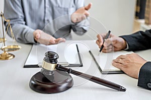 Judge gavel with scales of justice, Businessman and lawyer or counselor consulting and discussing contract papers at law firm in