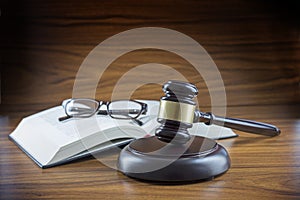 Judge gavel with sound board, book and glasses on a wooden desk, lawyers working place with justice symbol, concept for law and c