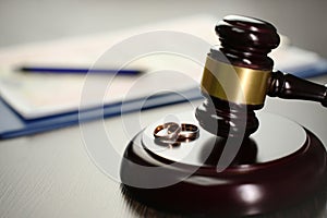 Judge gavel with wedding rings and divorce decree