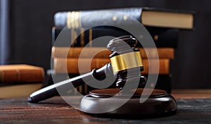 Judge gavel on a wooden desk, law books background