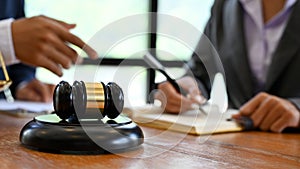 A judge gavel is on the wooden office desk over blurred background a lawyer meeting