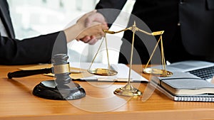 The judge hammer and the scales of a fair uncle on a table where a lawyer advises clients.