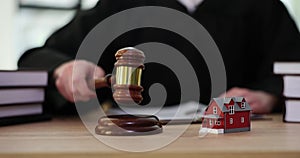Judge knocks judge wooden gavel on background of house