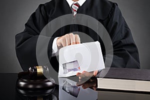 Judge Putting Money In Envelope