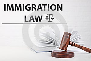 Judge`s gavel, book and words IMMIGRATION LAW on background