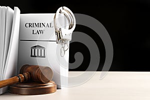 Judge`s gavel, Criminal Law book and handcuffs on table against black background. Space for text