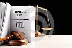 Judge`s gavel, Criminal Law book and scales on table against black background. Space for text