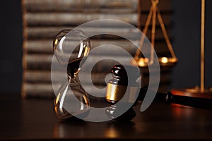 Judge`s gavel, scales of justice, books and hourglass on wooden table. Law concept