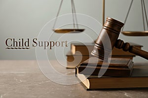 Judge`s gavel, scales of justice and books on marble table. Child support concept