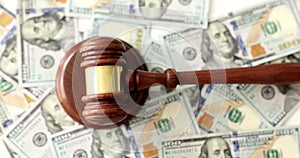 Judger or auctioneer gavel against background of cash dollars, closeup