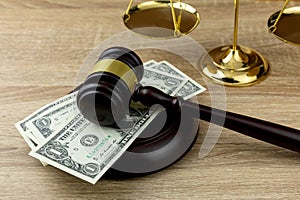 Judges gavel on dollar with wooden