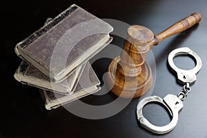 Judges Gavel, Handcuffs And Old Book On The Black Table