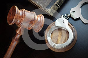 Judges Gavel, Handcuffs And Old Book On The Black Table