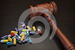 Judges Gavel And Medication On Black Wood Grunge Background