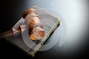 Judges Gavel And Old Book On The Black Wooden Table