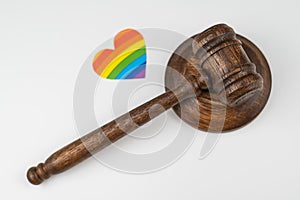 Judicial gavel and heart with rainbow flag on a white background. Protecting the rights of homosexuals in court.