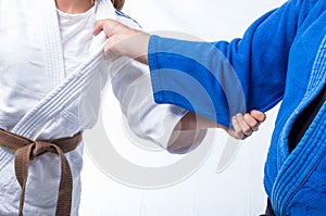 Judo Gripping between female judo brown belt and her sensei black belt isolated on white