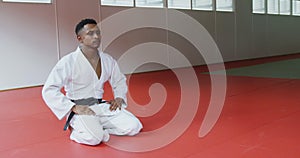 Judoka kneeling on the judo mat