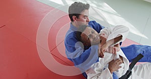 Judoka strangling his opponent on the judo mat