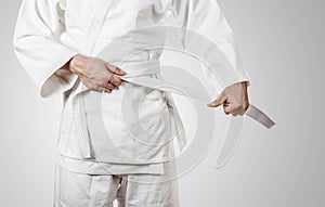 Judoka tying the white belt (obi) photo