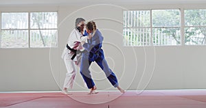 Judokas training by doing a randori on the judo mat