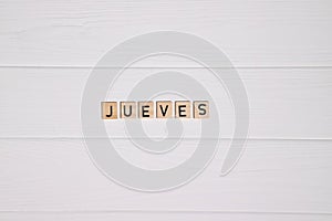 Jueves week day name on white wooden background photo