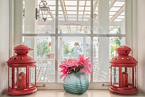 Jug of fresh summer flowers and lamps on a window sill