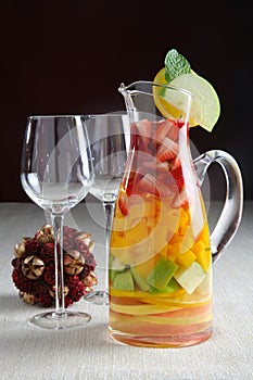 Jug with fruit salad and glasses
