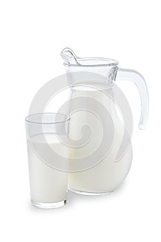 Jug and a glass completely filled with fresh cow milk stand on a clean white background