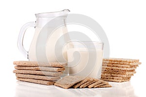 Jug and glass of milk with grain crispbreads isolated on white background