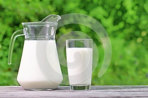 Jug and glass of milk on a wooden table