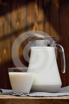 jug and glass of milk on wooden table